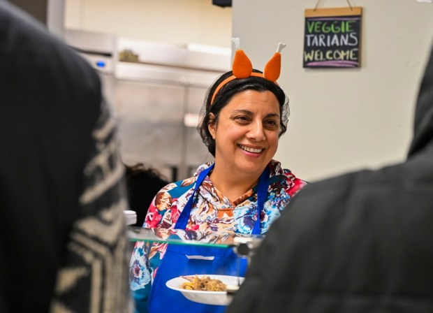 Volunteer Cindy Levin of Bethlehem Township smiles as she serves a meal Thursday, Nov. 27, 2025, during New Bethany's annual free Thanksgiving meal in Bethlehem. (April Gamiz/The Morning Call)