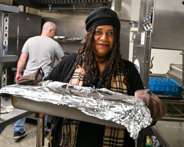 Food Access Director Brandy Garofalo carries a tray of food to be served Thursday, Nov. 27, 2025, during New Bethany's annual free Thanksgiving meal in Bethlehem. (April Gamiz/The Morning Call)