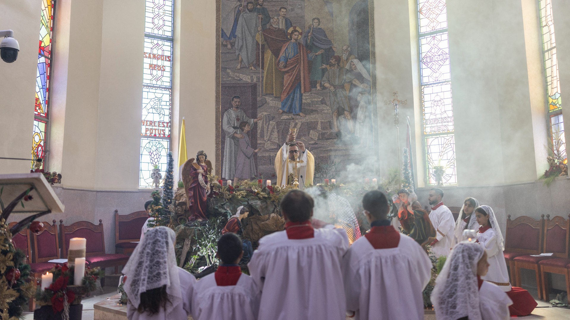 Abouna Bashar Basiel leads a Christmas morning mass at the Christ the Redeemer Church in the mostly Christian town of Taybeh, in the occupied West Bank
