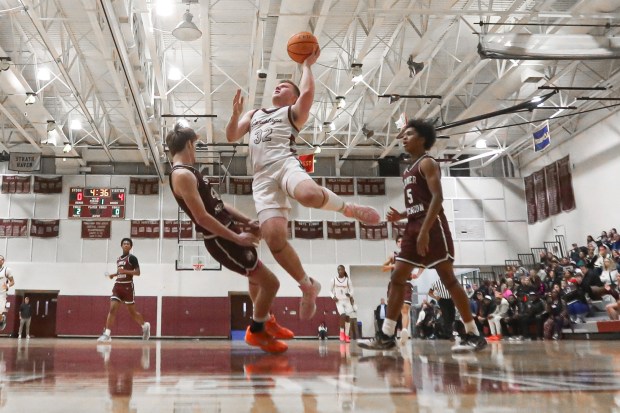 Conestoga's Corey Hogan shoots a basket over Lower Merion's Finn Pulsifer during Thursday's action. Photo by Tom Silknitter.