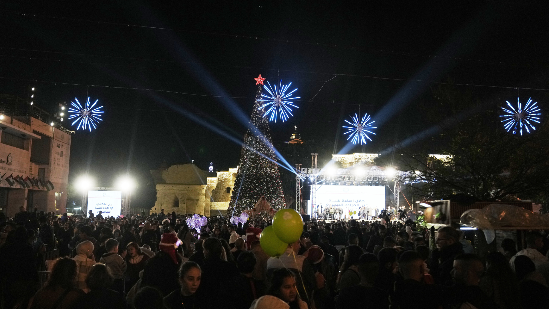 Palestinians take part in a Christmas tree-lighting event in Manger Square, next to the Church of the Nativity, traditionally regarded as the birthplace of Jesus Christ ahead of Christmas in the West Bank city of Bethlehem Saturday, Dec. 6, 2025.