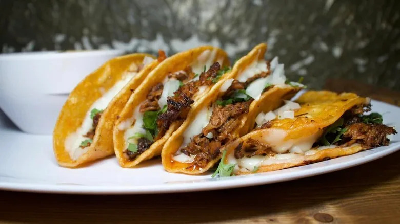 a row of cheesy tacos on a plate