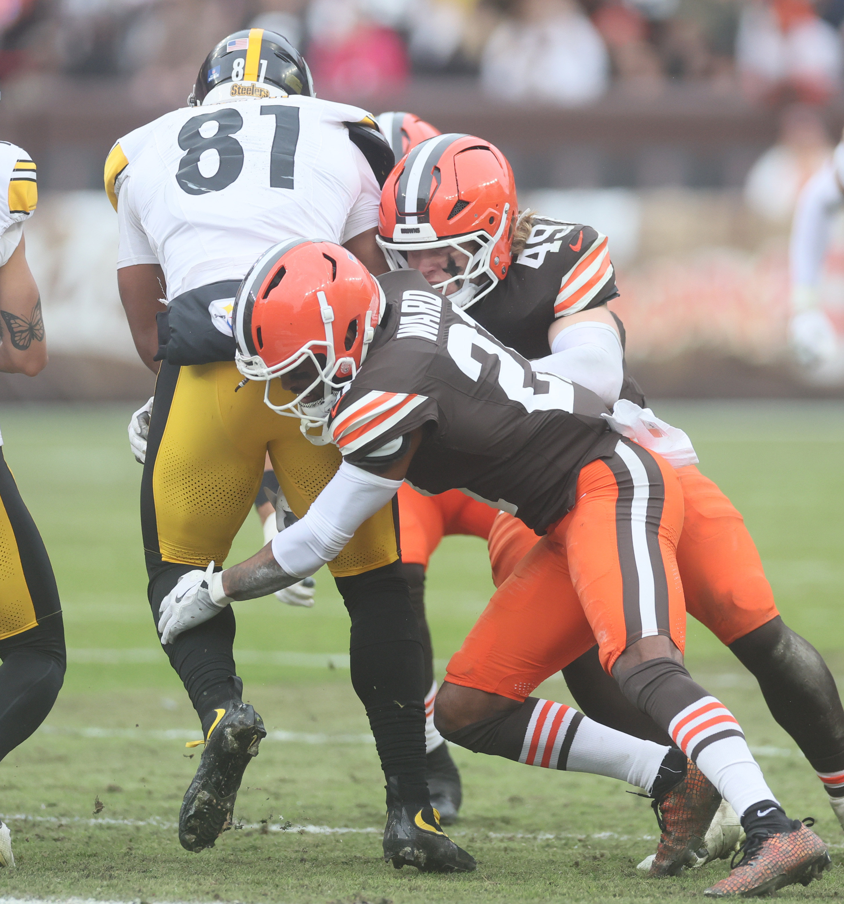 Cleveland Browns cornerback Denzel Ward and Cleveland Browns linebacker Carson Schwesinger team up to tackle Pittsburgh Steelers tight end Jonnu Smith after a reception in the first half. 