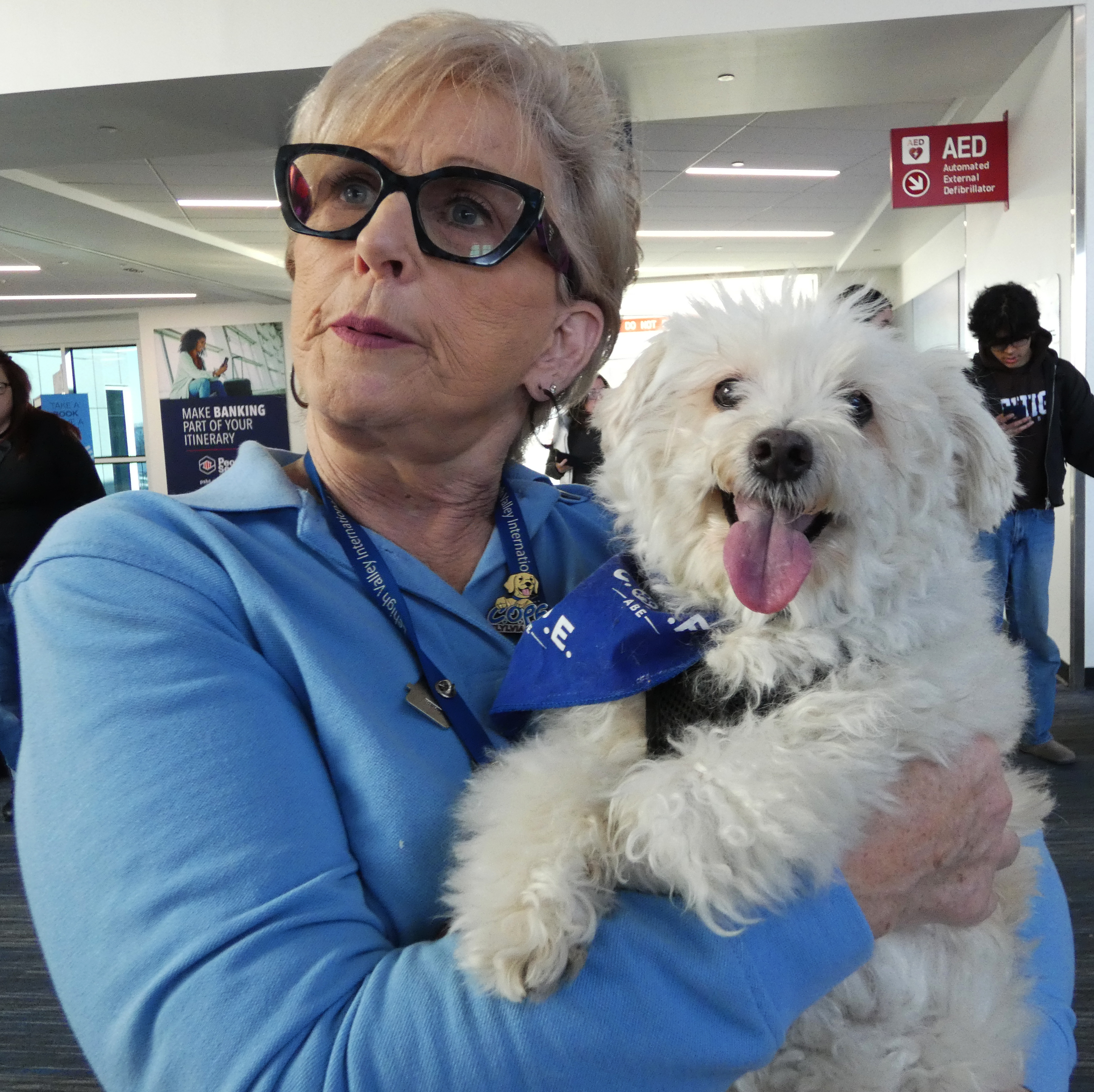Sue Ann Reibman holds Sherman, a Maltipoo (Maltese and the poodle mix), during a celebration Thursday, Dec. 18, 2025, of 10 years of Canines Offering Passengers Encouragement (C.O.P.E.) at Lehigh Valley International Airport. The two have been volunteers since the program's start in December 2015.