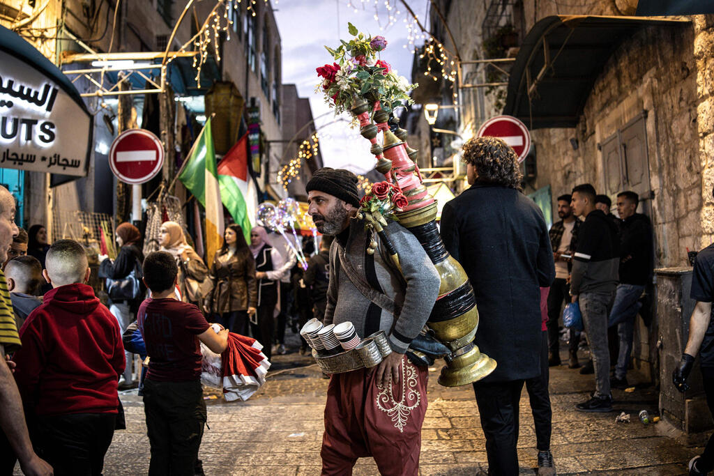 A man sells coffee in Nativity Square during a Christmas tree lighting ceremony in Bethlehem, West Bank, on December 6, 2025 