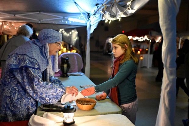 Jan Halman-Miller, left, helps Grace Alger, 8, make a percussion instrument during "A Night in Bethlehem" at Westminster United Methodist Church. (Thomas Walker/Freelance)