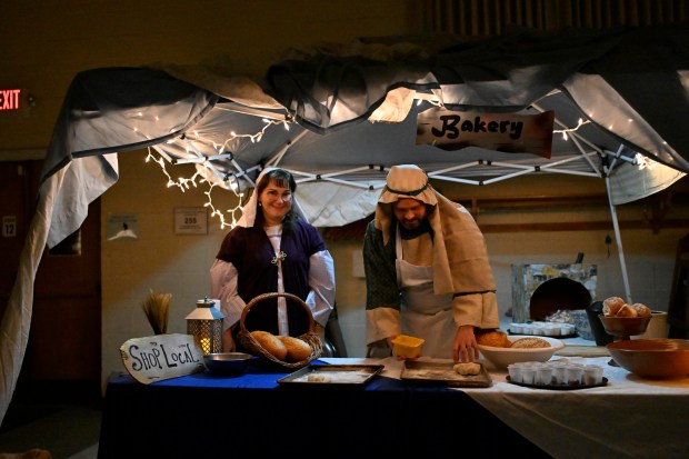 Michelle Bowman and Aaron Lyle offer samples of unleavened bread during "A Night in Bethlehem" at Westminster United Methodist Church. (Thomas Walker/Freelance)