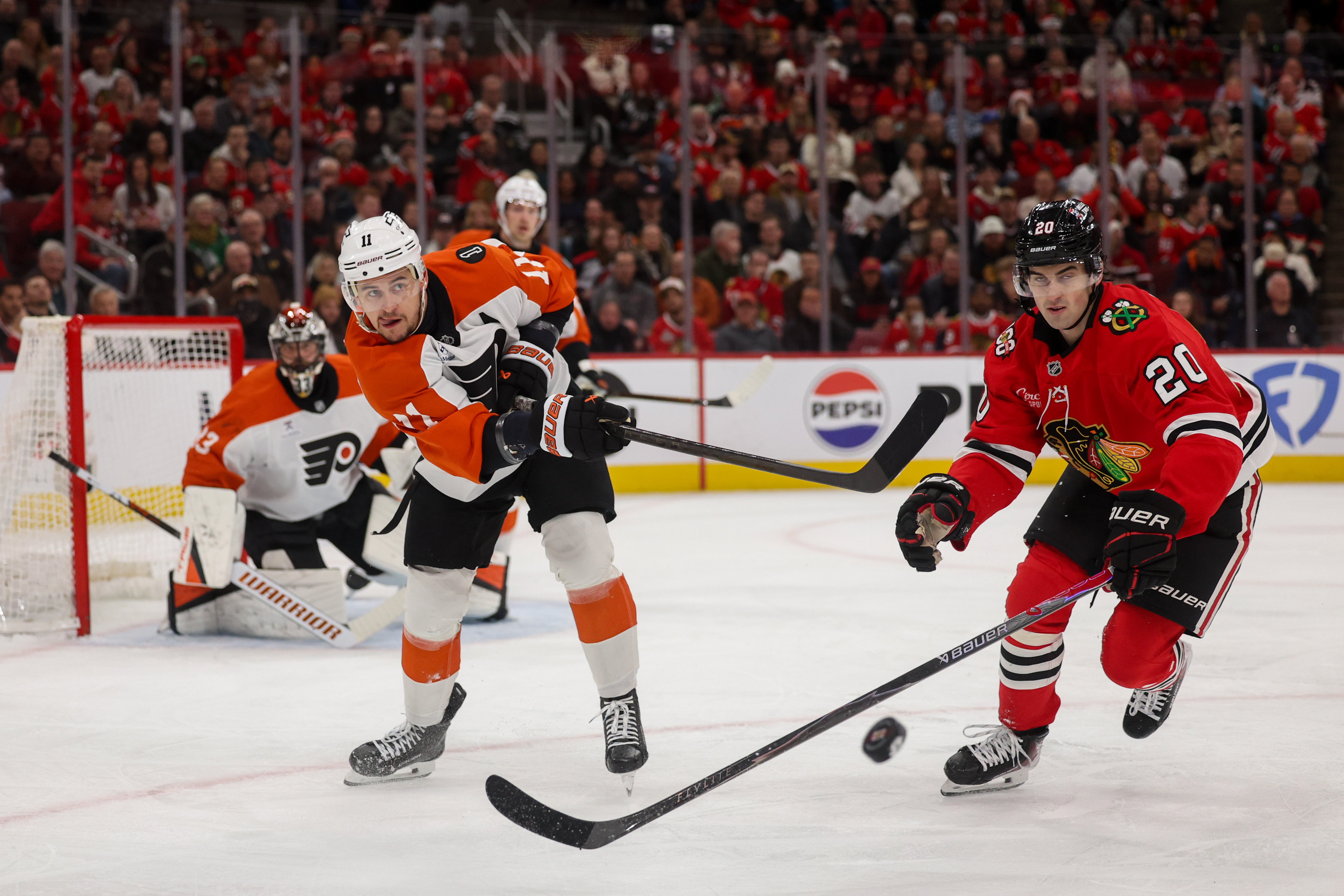 Chicago Blackhawks center Ryan Greene (20) guards Philadelphia Flyers right wing Travis Konecny (11) while he passes the puck during the first period at the United Center Tuesday Dec. 23, 2025 in Chicago. (Armando L. Sanchez/Chicago Tribune)