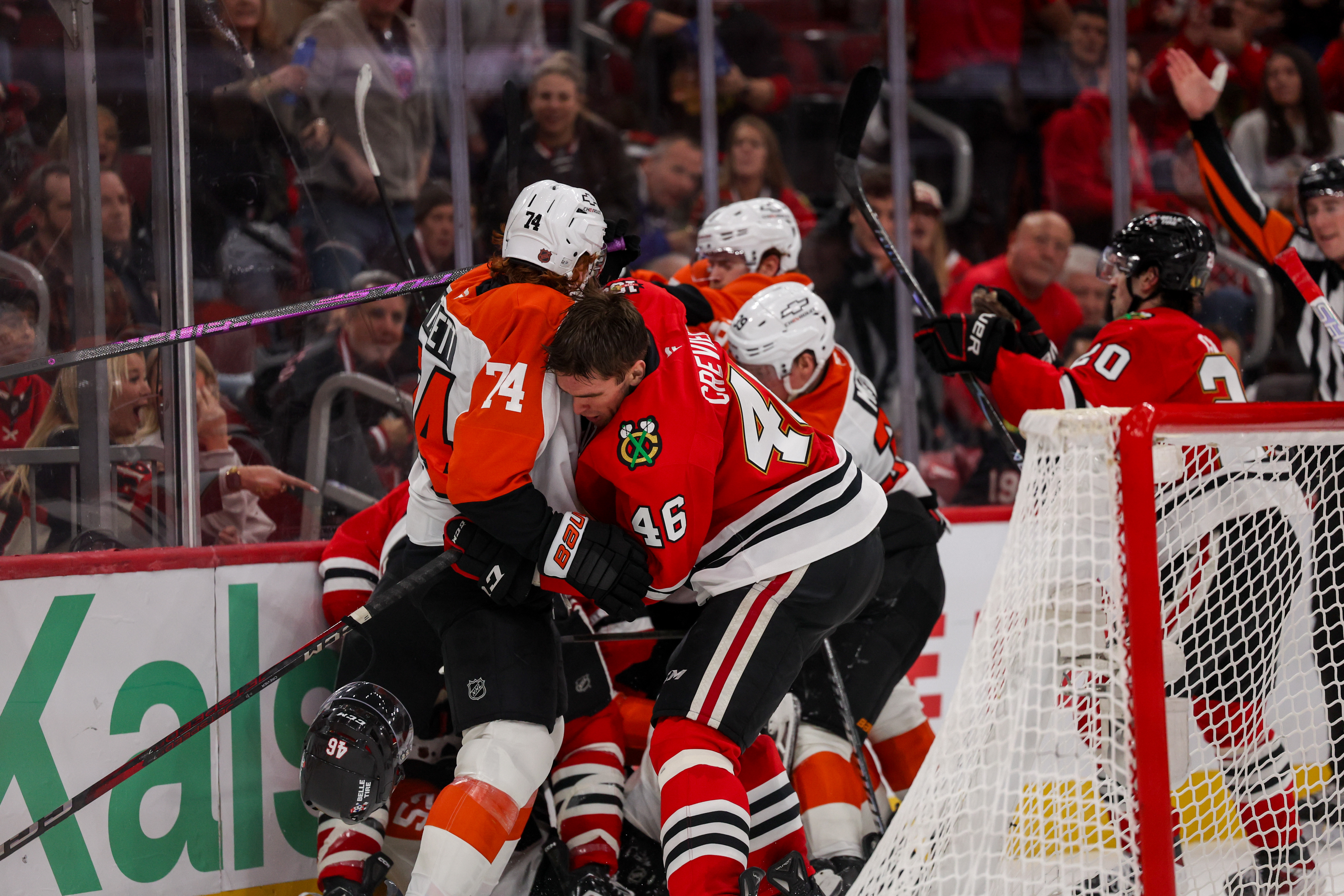 Chicago Blackhawks defenseman Louis Crevier (46) loses his helmet while pushing against Philadelphia Flyers right wing Owen Tippett (74) during the second period at the United Center Tuesday Dec. 23, 2025 in Chicago. (Armando L. Sanchez/Chicago Tribune)