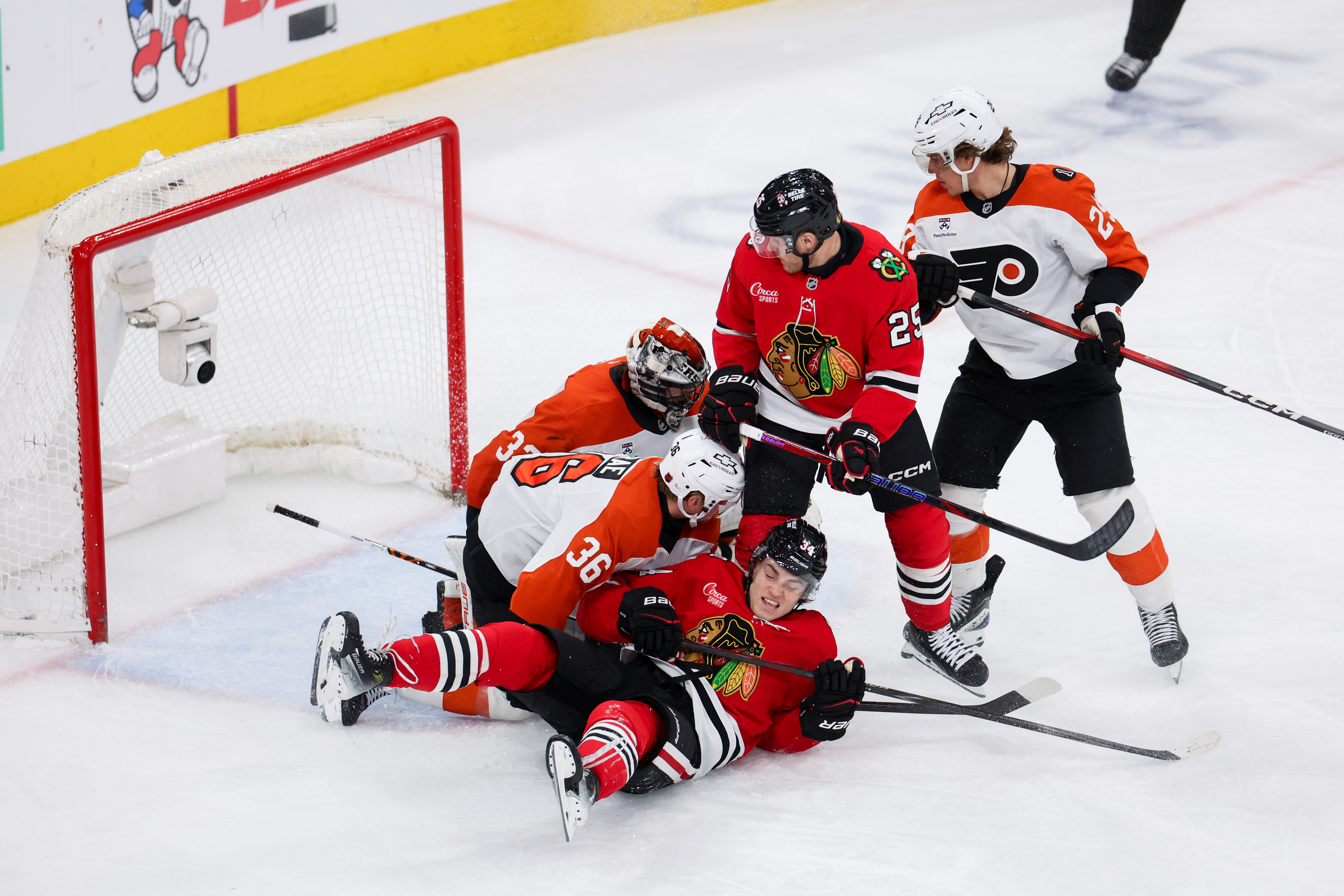 Philadelphia Flyers defenseman Emil Andrae (36) stands over Chicago Blackhawks center Colton Dach (34) after he fell on the ice near the goal during the third period at the United Center Tuesday Dec. 23, 2025 in Chicago. (Armando L. Sanchez/Chicago Tribune)