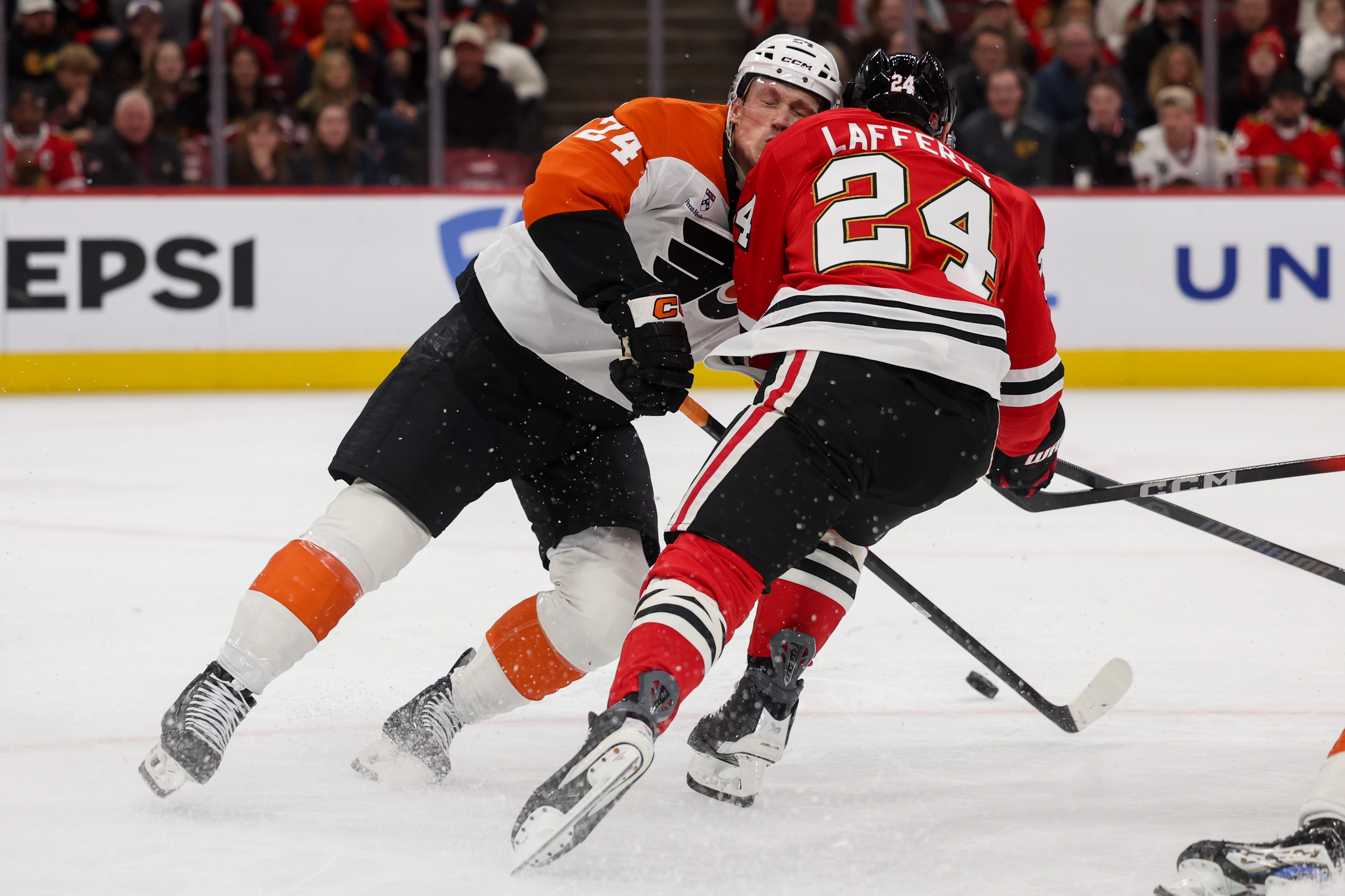 Chicago Blackhawks center Sam Lafferty (24) runs into Philadelphia Flyers defenseman Nick Seeler (24) while chasing after the puck during the first period at the United Center Tuesday Dec. 23, 2025 in Chicago. (Armando L. Sanchez/Chicago Tribune)