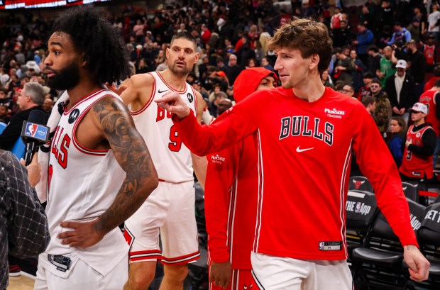 Chicago Bulls center Nikola Vučević (9) and Chicago Bulls forward Matas Buzelis (14) poke Chicago Bulls guard Coby White (0) while he was being interviewed after they won against the Philadelphia 76ers, Friday, Dec. 26, 2025, at the United Center in Chicago. (Dominic Di Palermo/Chicago Tribune)