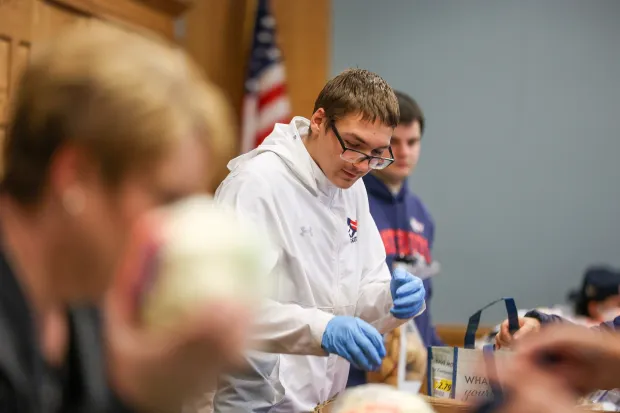 Gavin Migliori, a senior member of the Pittston Area football team, sorts through potatoes during the launch of the Pittston City Food Distribution Pantry at the Pittston Memorial Library on Thursday, Dec. 11, 2025. (JASON ARDAN / STAFF PHOTOGRAPHER)