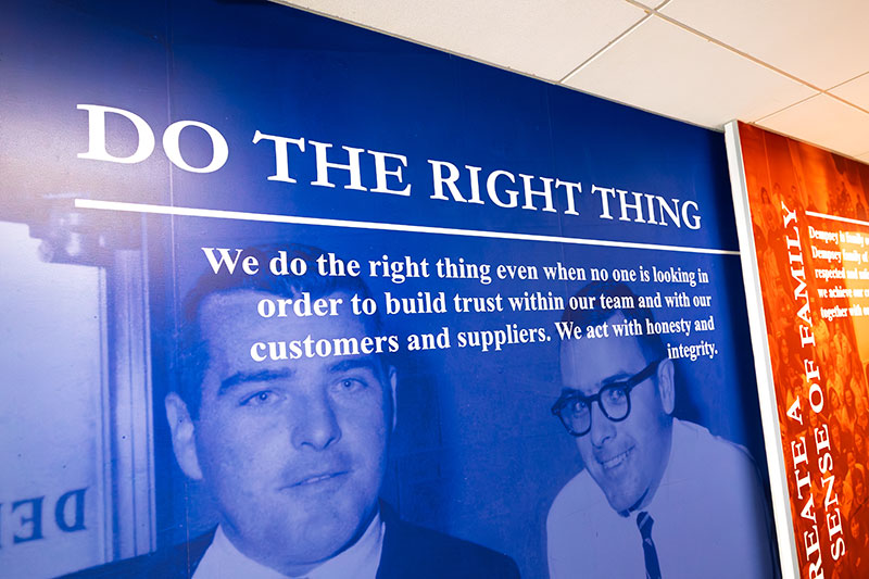 A company values display inside Dempsey Uniform & Linen Supply’s Jessup, PA, headquarters honoring family leadership and integrity.