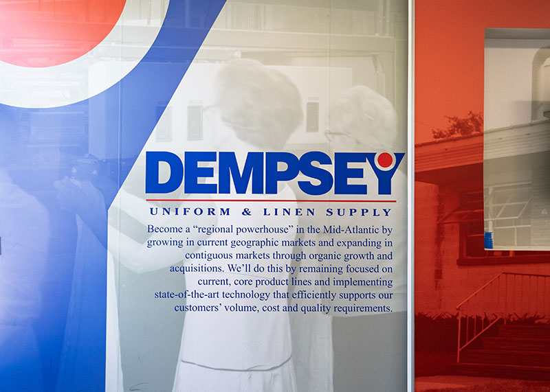 Dempsey Uniform & Linen Supply branding and mission statement displayed inside the Jessup, Pennsylvania, plant.