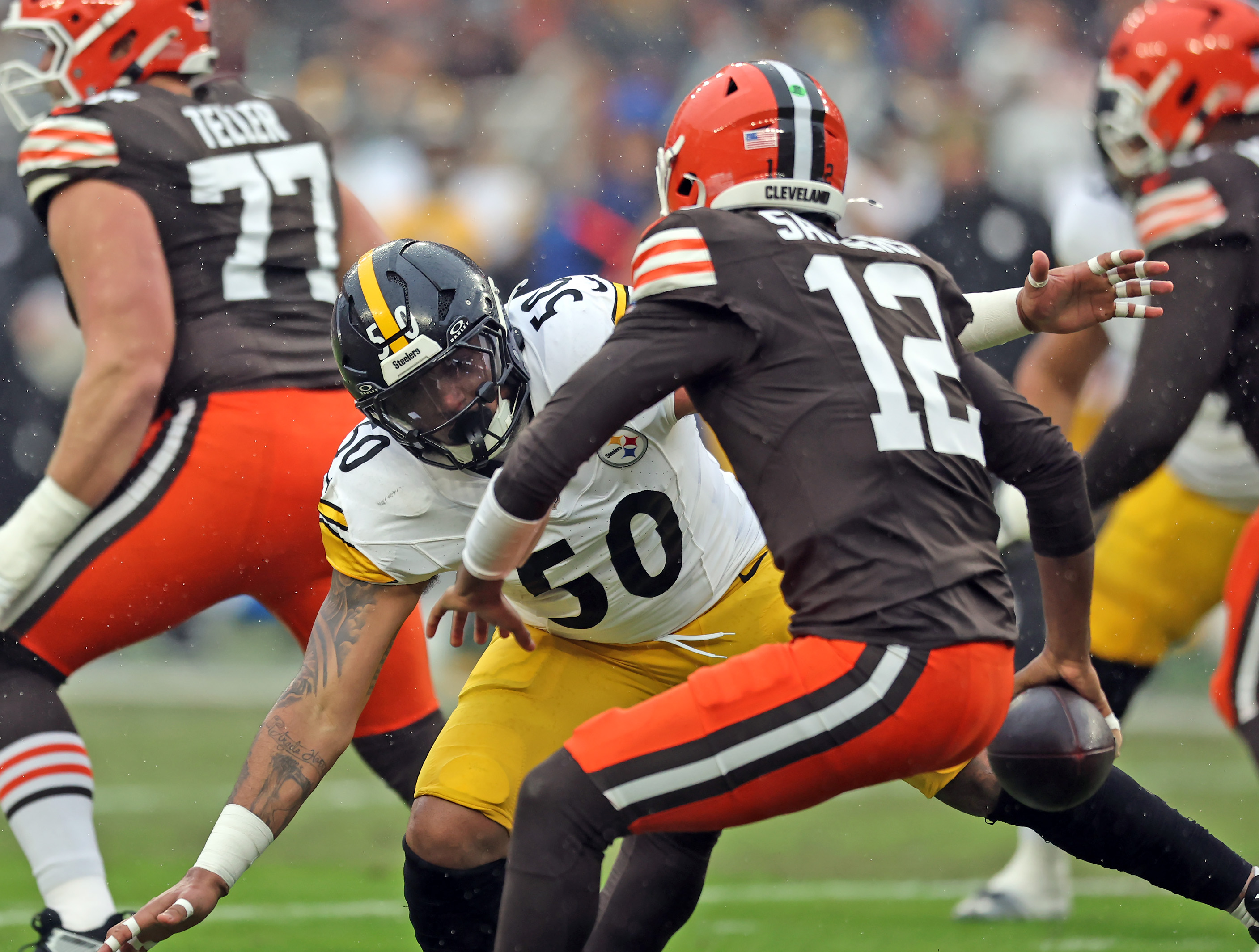 Cleveland Browns quarterback Shedeur Sanders scrambles to evade Pittsburgh Steelers linebacker Malik Harrison in the first half of play. 