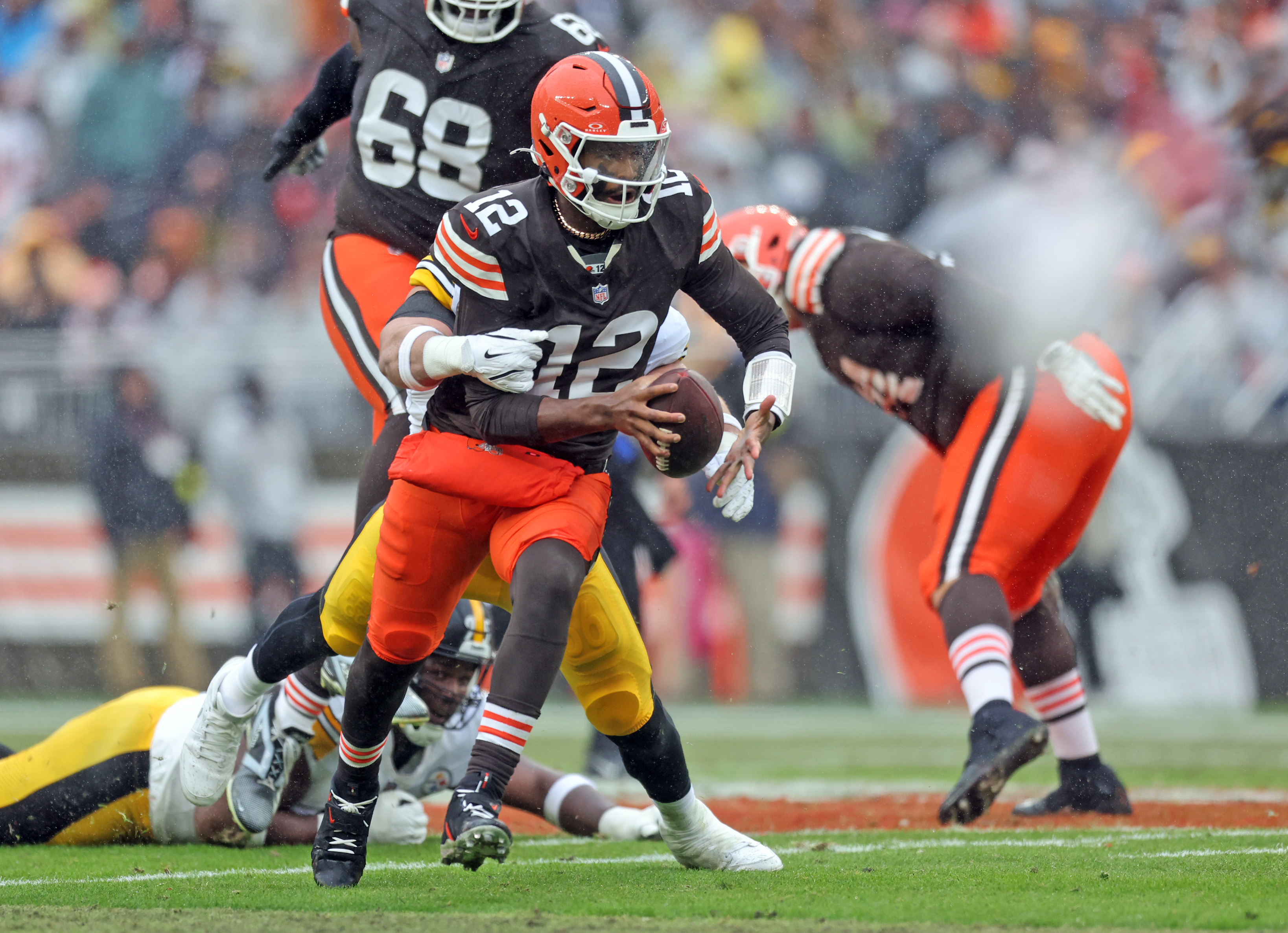 Cleveland Browns quarterback Shedeur Sanders scrambles as Pittsburgh Steelers linebacker Alex Highsmith comes in for the tackle in the first half of play. 