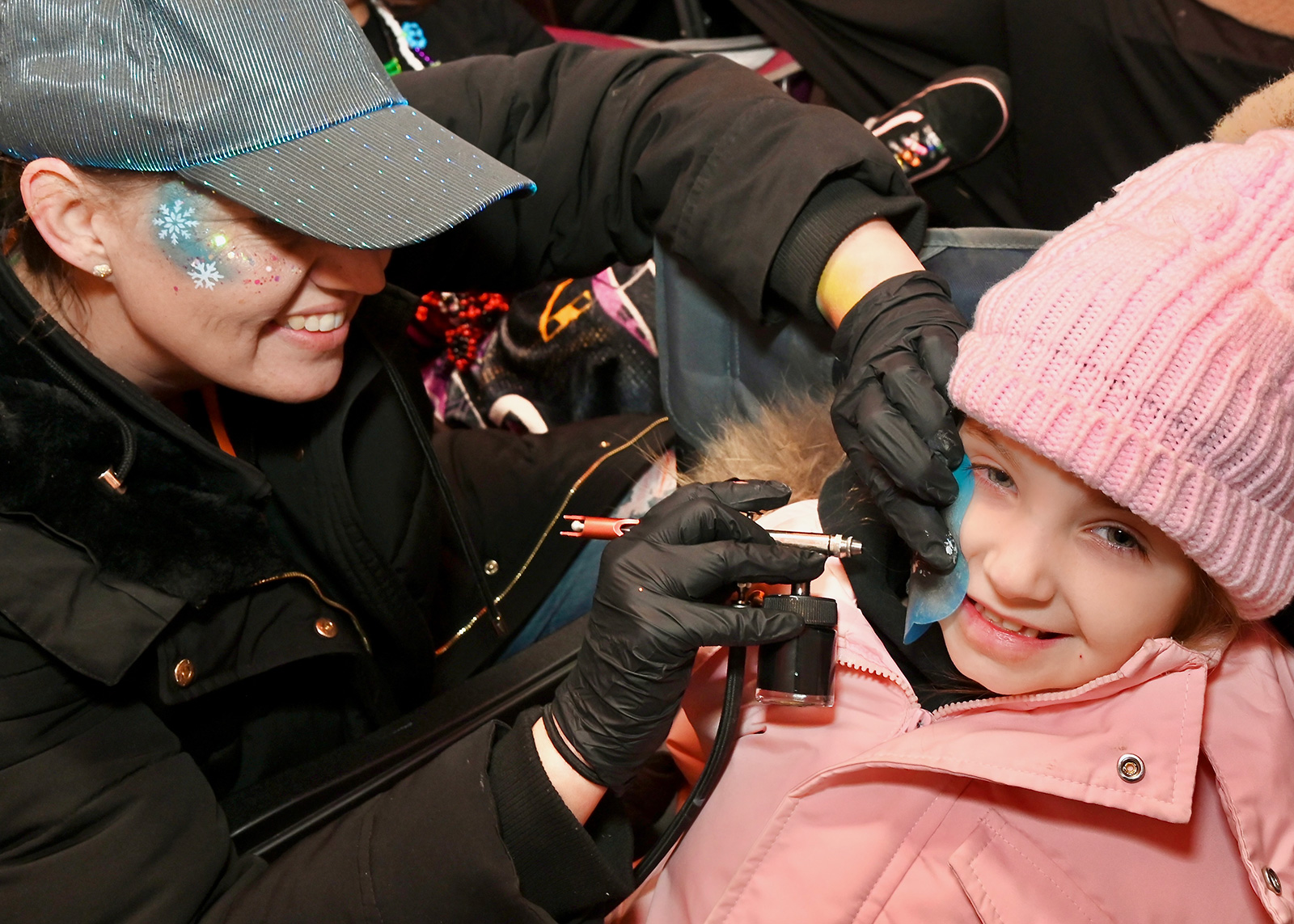 Carrie Ward airbrush paints the character Stitch for Paisley McCall,...