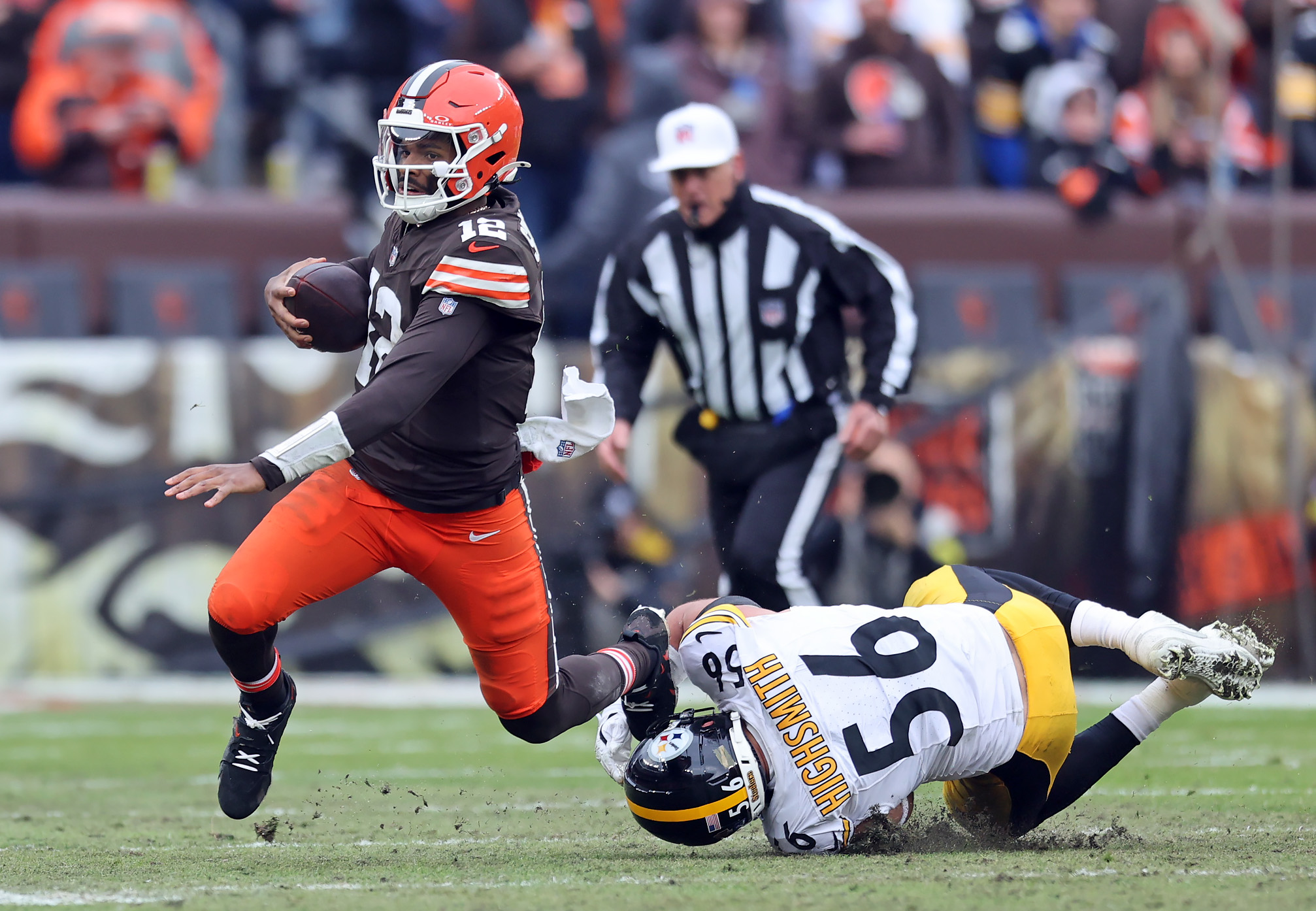 Cleveland Browns quarterback Shedeur Sanders scrambles as Pittsburgh Steelers linebacker Alex Highsmith trips him up in the second half of play. 