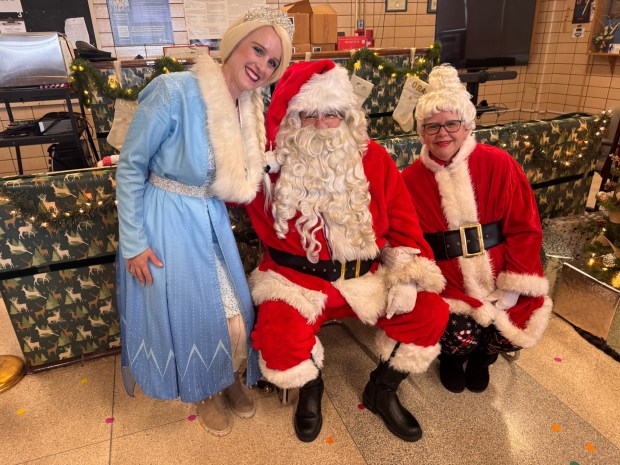 Elsa the Snow Queen, with the Claus twosome, graciously greeted each child upon receiving their gifts. (Photo by Rick Cawley)