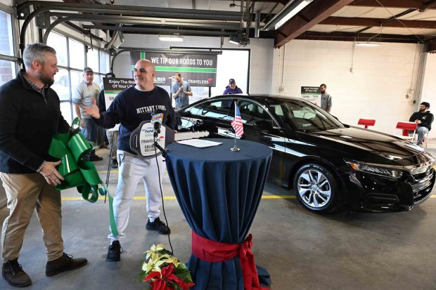 Ryan Zipay of Caliber Collision, left, congratulates Keith Fry after unveiling a 2019 Honda Accord during a presentation ceremony at Caliber Collision, 2526 Centre Ave., on Thursday, Dec. 18, 2025. (BILL UHRICH/READING EAGLE)