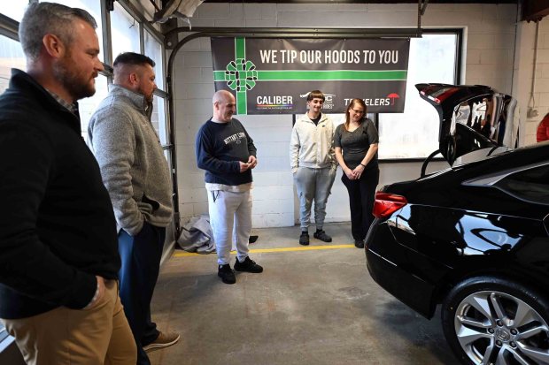Ryan Zipay of Calber Collision, left, and Jeremy Bender of Traveler's Insurance present a 2019 Honda Accord to Ketih and Jessica Fry and their son Jordan, 15, during a ceremony at Caliber Collision, 2526 Centre Ave., on Thursday, Dec. 18, 2025. (BILL UHRICH/READING EAGLE)