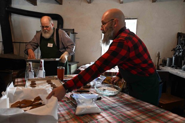 Terry Baker of Carbon County, left, and Jeffrey Primaldi of Gordonville, Lancaster County,p prepare ox-tongue cookies in the summer kitchen during the Christmas on the Farm at the Pennsylvania German Heritage Center at Kutztown University on Saturday, dec. 6, 2025.. (BILL UHRICH/READING EAGLE)