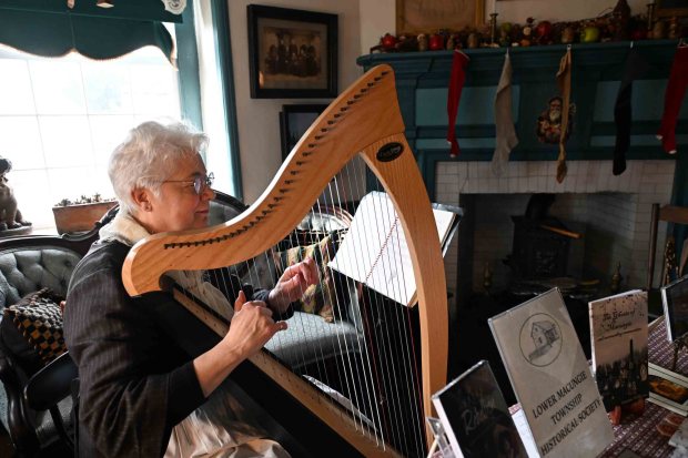 Sarajane Williams of Macungie, Lehigh County, plays a 34-string harp during the Christmas on the Farm at the Pennsylvania German Heritage Center at Kutztown University on Saturday, dec. 6, 2025.. (BILL UHRICH/READING EAGLE)