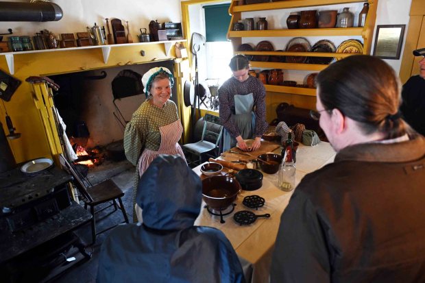 Becky Manley of Phoenixville, left, and Mary Riebold of Allentown bake pumpking pies using redware during the Christmas on the Farm at the Pennsylvania German Heritage Center at Kutztown University on Saturday, dec. 6, 2025.. (BILL UHRICH/READING EAGLE)