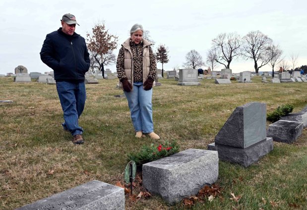 Chris and Leeann DeFusco of East Nantmeal Township, Montgomery County, place a wreath at the grave of Leeann's grandfather, a WWI veteran, during a Wreaths Across America ceremony at Gethsemane Cemetery in Muhlenberg Township on Saturday, Dec. 13, 2025. (BILL UHRICH/READING EAGLE)