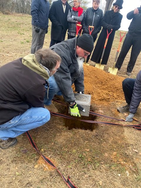Berks County Parks and Recreation staff members lower a time capsule assembled to mark the United Way of Berks County's 100th anniversary. (Courtesy of United Way of Berks County)