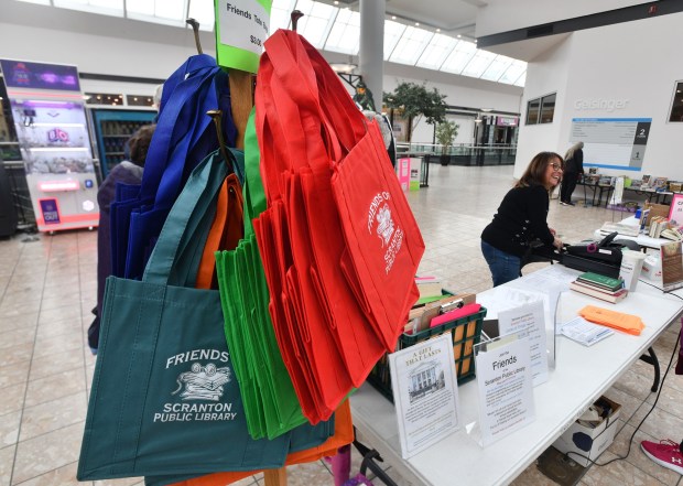 Tote bags are sold during the The Friends of the Scranton Public Library Book Sale at The Marketplace at Steamtown in Scranton Thursday. (SEAN MCKEAG / STAFF PHOTOGRAPHER)