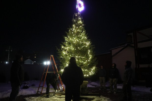 Volunteers light the Christmas tree at the pocket park on East Drinker St. in Dunmore on Wednesday, Dec. 3, 2025. (REBECCA PARTICKA/STAFF PHOTOGRAPHER)