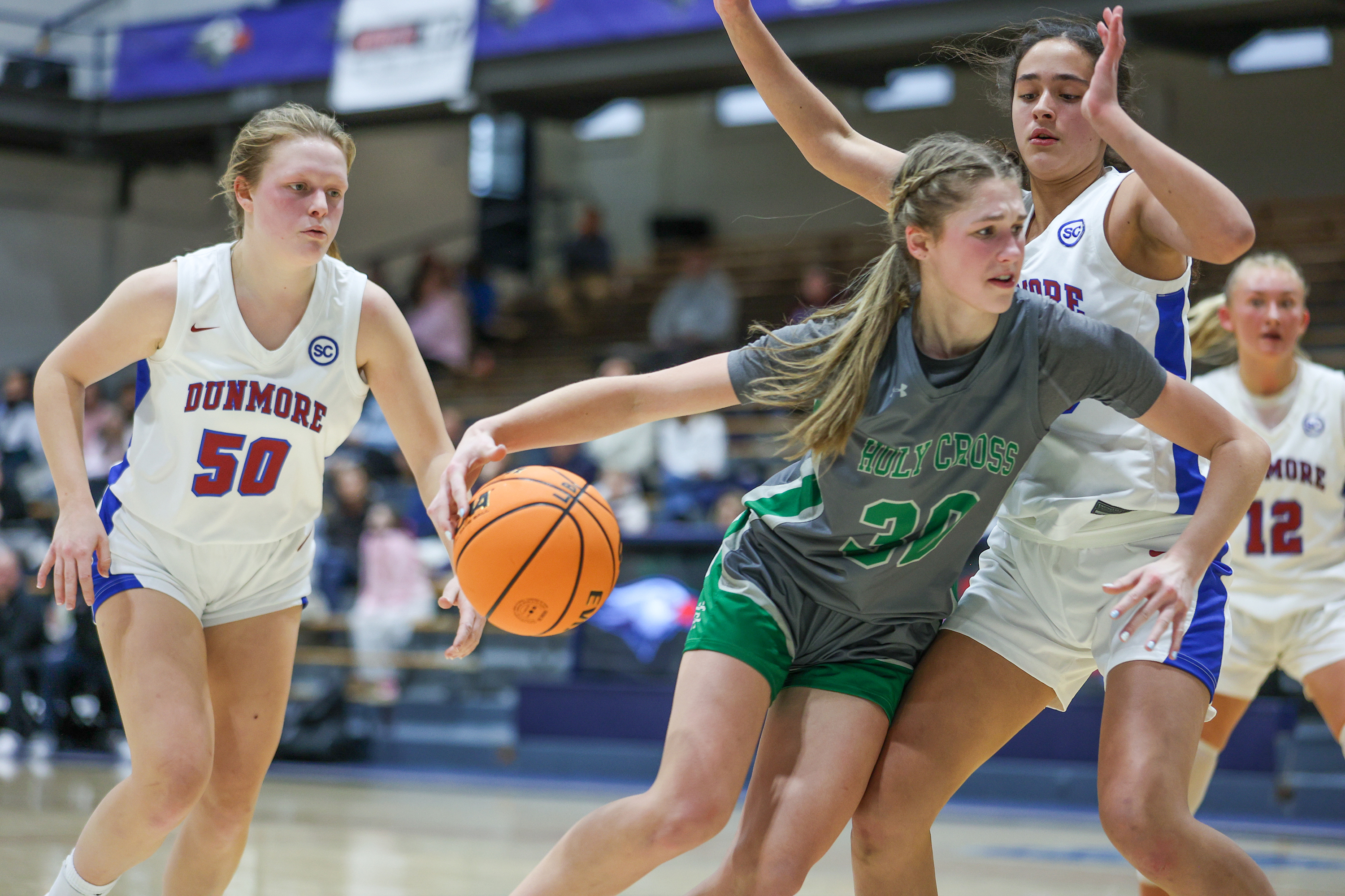 Holy Cross’ Ava Schmidt (30) drives toward the basket during...