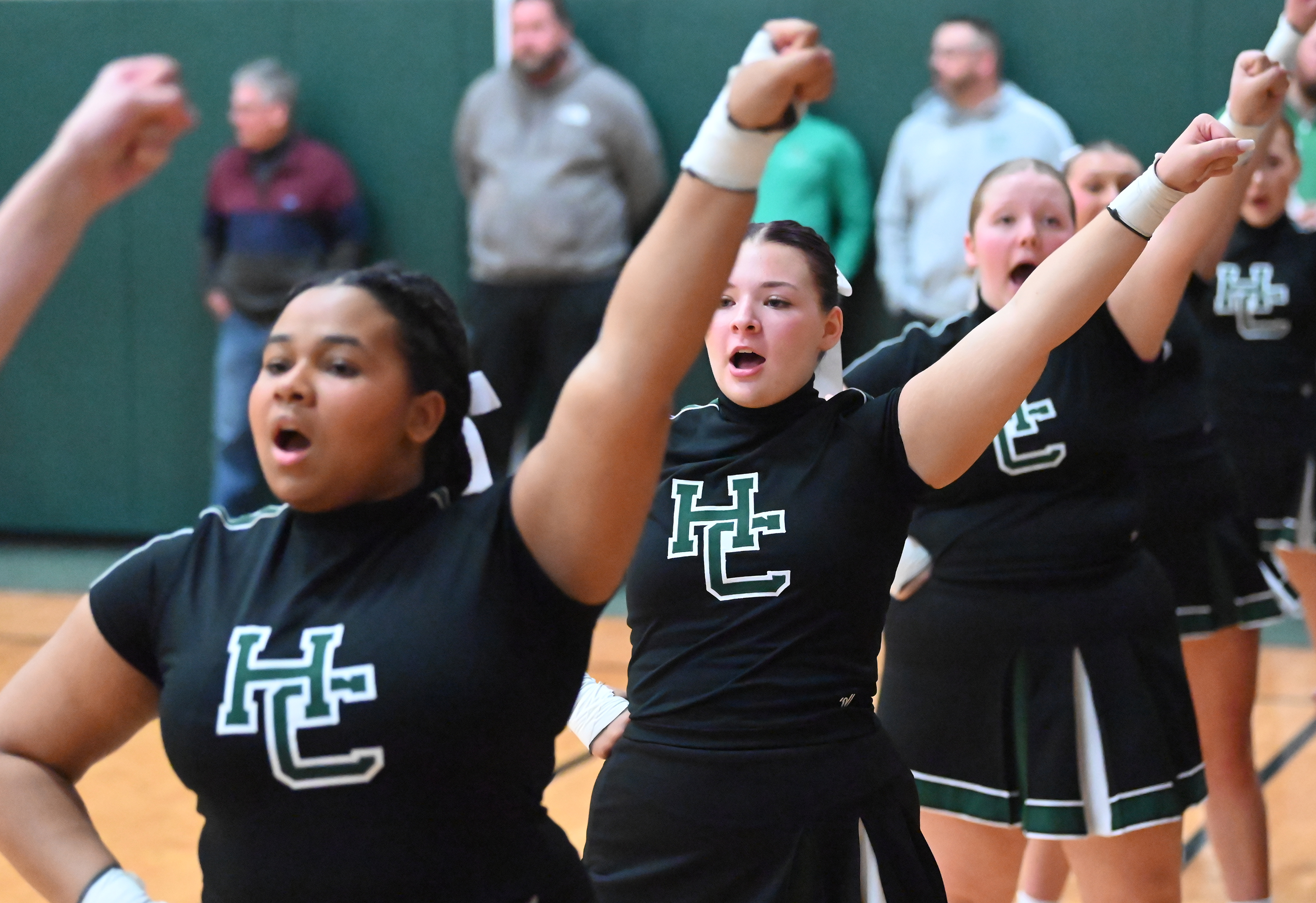 Holy Cross cheerleaders perform as their basketball team runs onto...