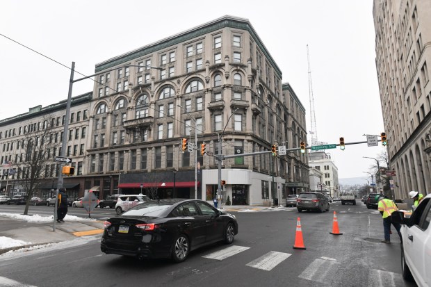 Vehicles drive through the intersection of Wyoming Ave. and Biden St. past Hotel Jermyn in downtown Scranton Wednesday, December 10, 2025. (SEAN MCKEAG / STAFF PHOTOGRAPHER)