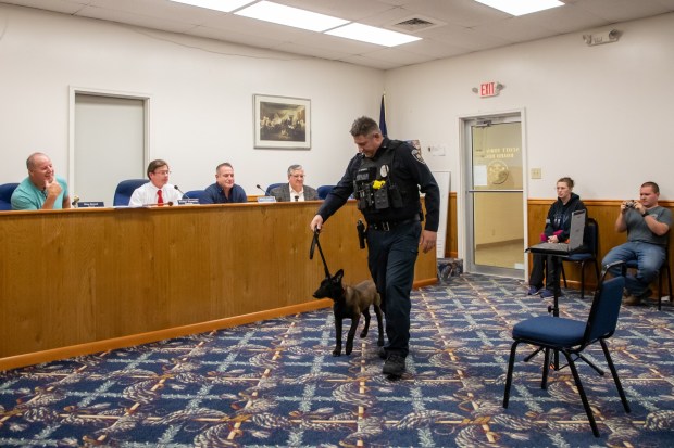 Scott Twp. Police Patrolman James Bassani walks his new partner, a 5-month-old Belgian Malinois named Redd, into the Scott Twp. supervisors meeting at the Scott Twp. Municipal Building on Tuesday, Dec. 16, 2025. (REBECCA PARTICKA/STAFF PHOTOGRAPHER)