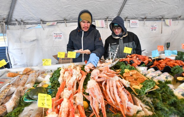Ian Lopera and Matthew Cooper stocks snow crabs at the outdoor seafood market at Cooper's Seafood House in Scranton Tuesday, December 30, 2025. (SEAN MCKEAG / STAFF PHOTOGRAPHER)