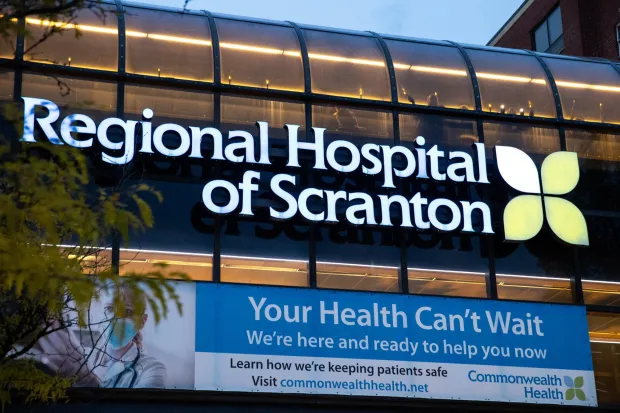Regional Hospital workers hold candles as they stand on the hospital's bridge over Jefferson Avenue in Scranton as the hospital's unionized workers and they supporters attend a candlelight vigil on Thursday, Oct. 19, 2023. (CHRISTOPHER DOLAN / STAFF PHOTOGRAPHER)