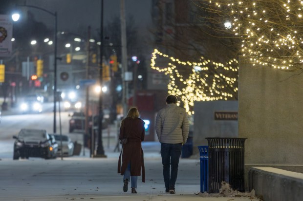 A man and a woman walk through frozen rain at Courthouse Square in Scranton on Friday, Dec. 26, 2025. (JASON ARDAN / STAFF PHOTOGRAPHER)