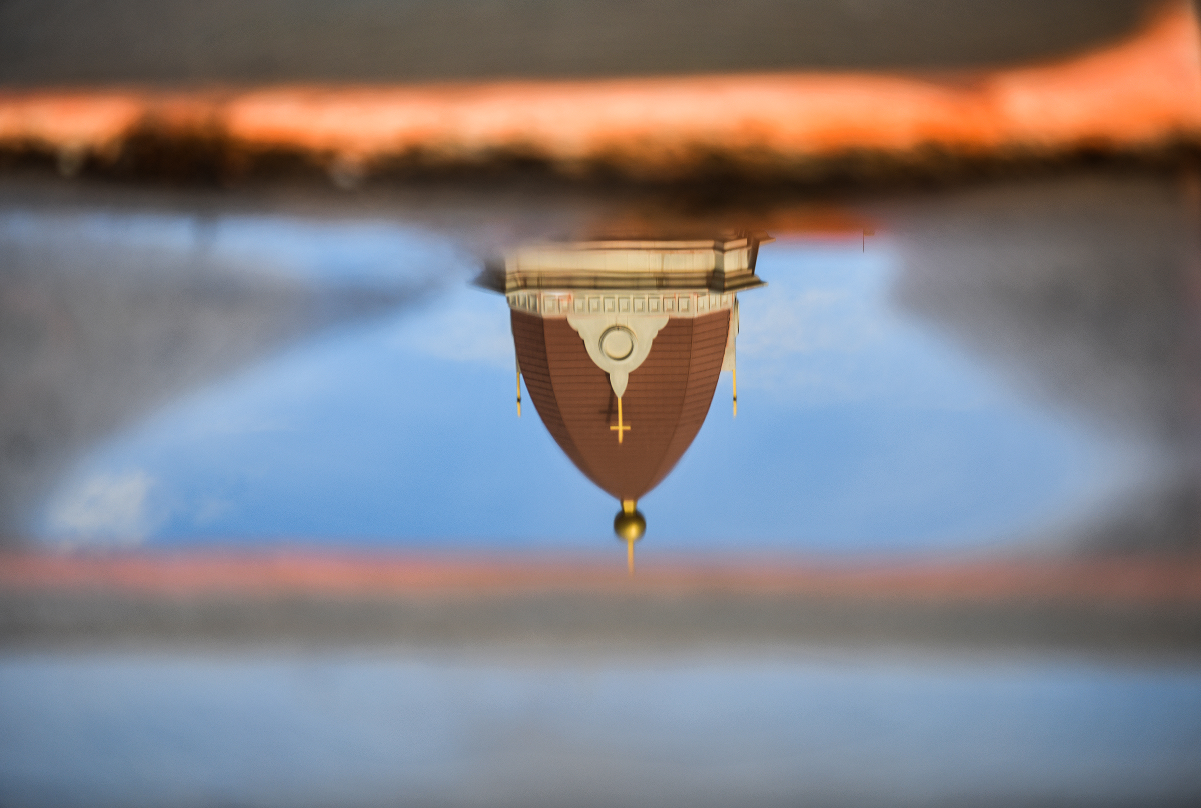 St. Peter’s Cathedral is reflected in a puddle on the...