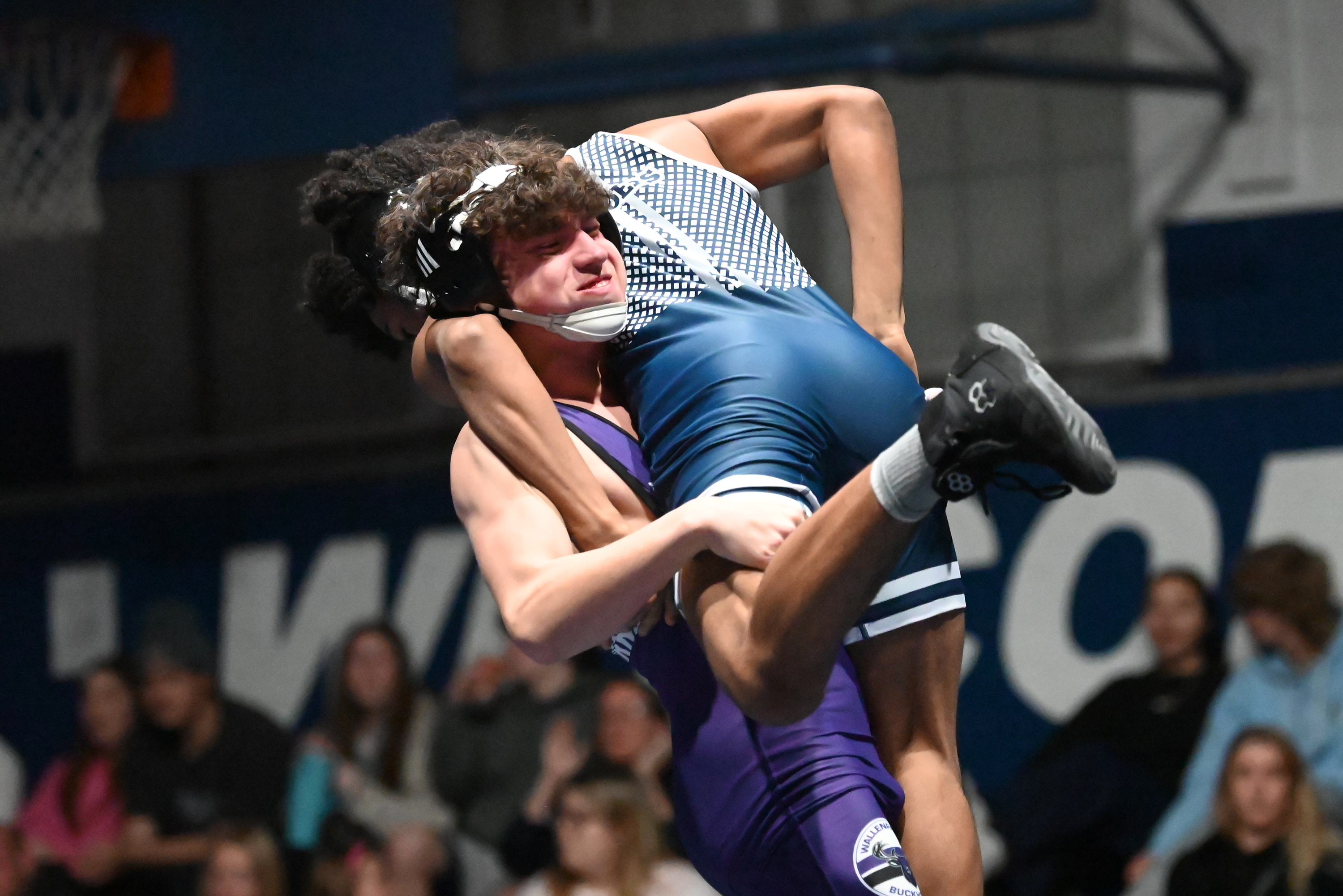 Wallenpaupack’s Kyle Scartelli lifts West Scranton’s Reggie Rollins off the...