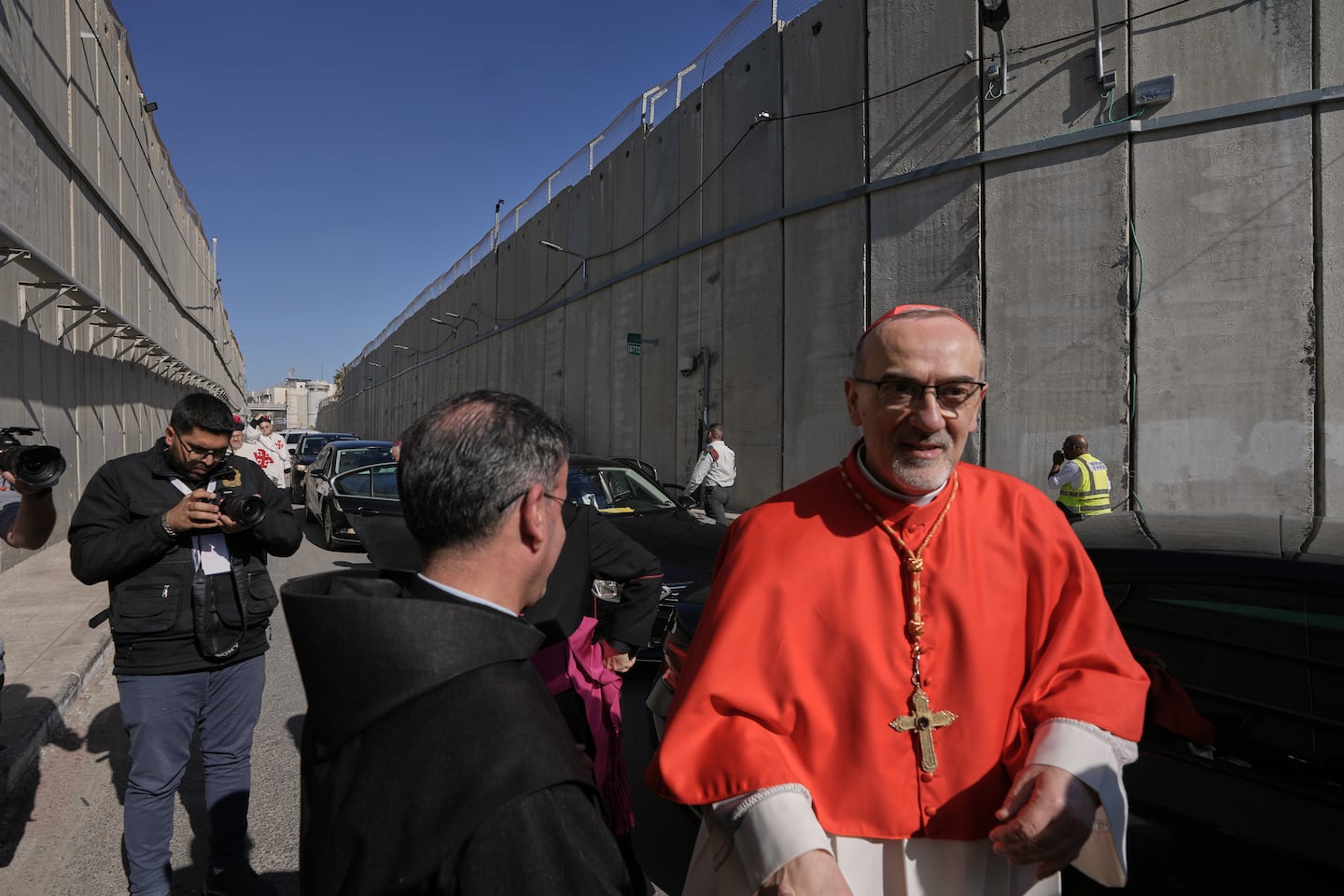 Latin Patriarch Pierbattista Pizzaballa, the top Catholic clergyman in the Holy Land, is received by local community while crossing an Israeli military checkpoint from Jerusalem ahead of celebrations at the Church of the Nativity, traditionally believed to be the birthplace of Jesus, on Christmas Eve, in the West Bank city of Bethlehem.