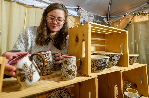First year vendor Madison Moreno of Madison's Ceramics restocks her handmade ceramic mugs inside the Handwerk Haus on Saturday, Dec. 20, 2025, during Christkindlmarkt in Bethlehem. The German-inspired holiday market, which closes Sunday, Dec. 21, 2025, features artisan vendors, festive treats and family activities. (April Gamiz/The Morning Call)