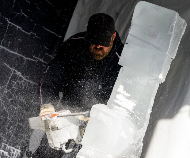 Roy Witten of Sculpted Ice Works carves an ice sculpture as people watch Saturday, Dec. 20, 2025, during Christkindlmarkt in Bethlehem. The German-inspired holiday market, which closes Sunday, Dec. 21, 2025, features artisan vendors, festive treats and family activities. (April Gamiz/The Morning Call)