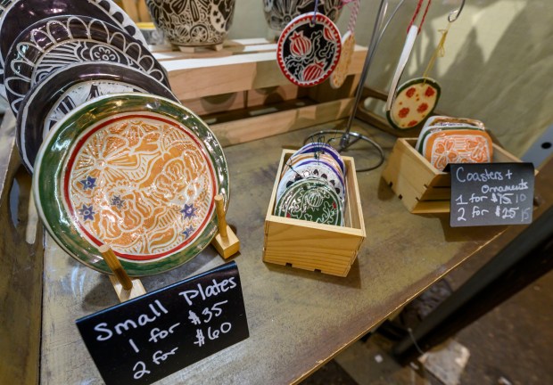 First year vendor Madison Moreno of Madison's Ceramics restocks her handmade ceramic mugs inside the Handwerk Haus on Saturday, Dec. 20, 2025, during Christkindlmarkt in Bethlehem. The German-inspired holiday market, which closes Sunday, Dec. 21, 2025, features artisan vendors, festive treats and family activities. (April Gamiz/The Morning Call)
