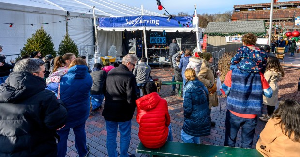 Roy Witten of Sculpted Ice Works carves an ice sculpture as people watch Saturday, Dec. 20, 2025, during Christkindlmarkt in Bethlehem. The German-inspired holiday market, which closes Sunday, Dec. 21, 2025, features artisan vendors, festive treats and family activities. (April Gamiz/The Morning Call)