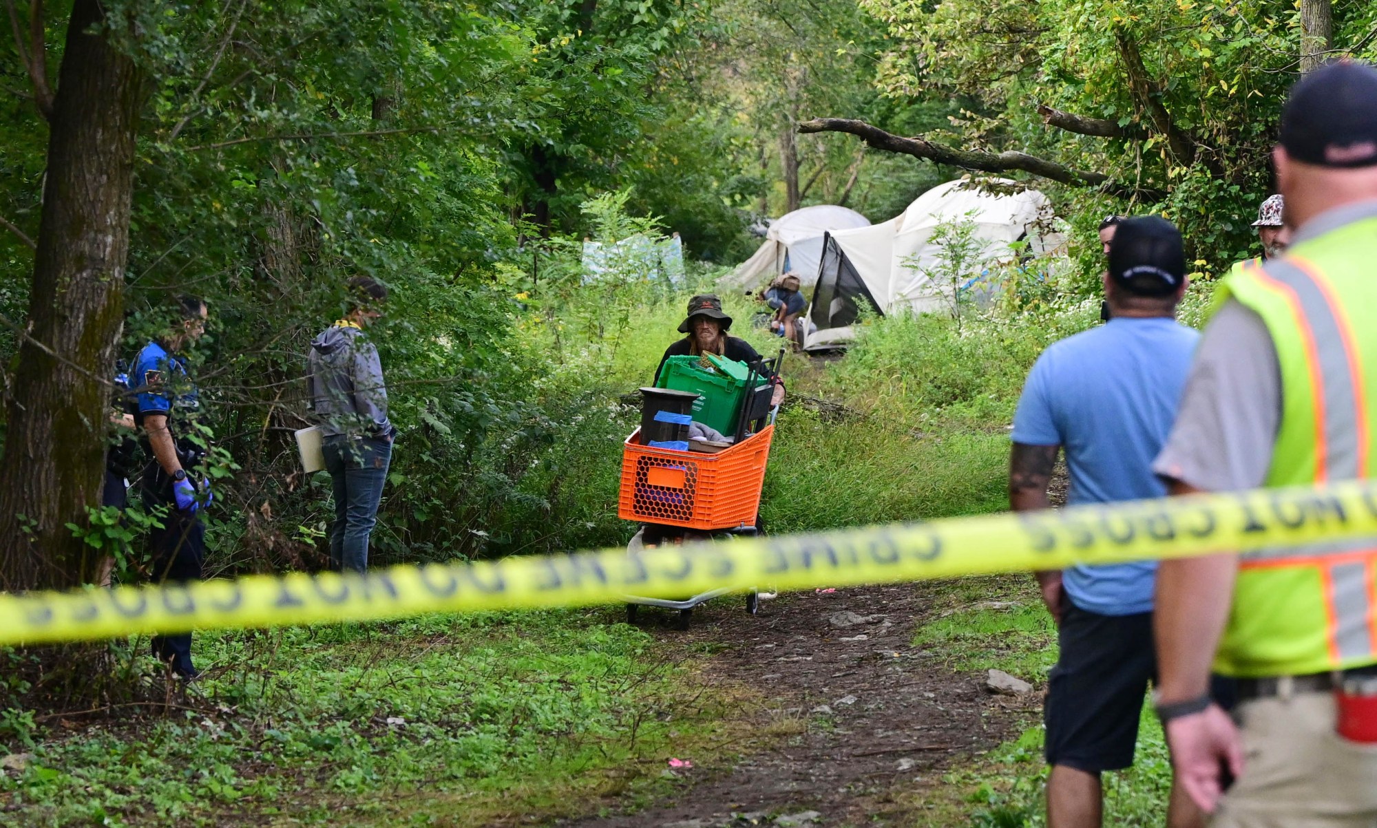 Residents of the Jordan Creek homeless encampment in Allentown carry their belongings Monday, Sept. 29, 2025, as city officials sweep through the site to clear it out. While many residents were able to grab their belongings, others said they lost a lot because they didn't have help. Allentown officials announced in early August that the camp would be cleared, citing flooding concerns. After an initial deadline of Aug. 25, Allentown Mayor Matt Tuerk extended the evacuation date to Monday to coincide with the opening of the Allentown YMCA's warming station. Despite the advance warning, however, some of the residents stayed up until the last possible moment, saying they had nowhere else to go. (Monica Cabrera/The Morning Call)