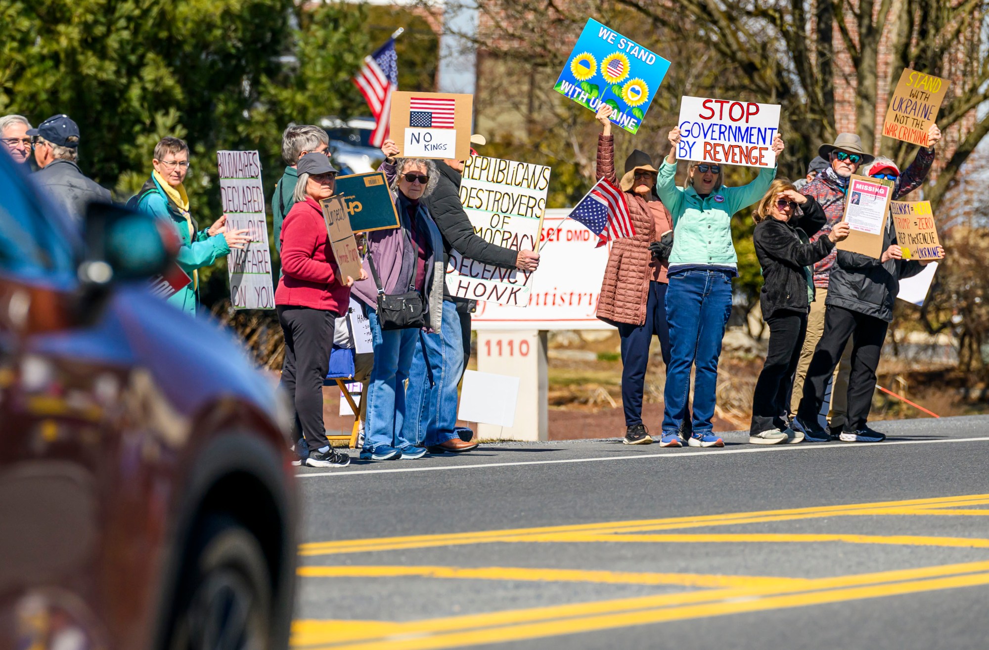People hold up signs as traffic passes by Monday, March 10, 2025, during a weekly Mondays with Mackenzie protest against U.S. Rep. Ryan Mackenzie, R-Pa., outside of Mackenzie's office along Cedar Crest Boulevard in Salisbury Township. (April Gamiz/The Morning Call)