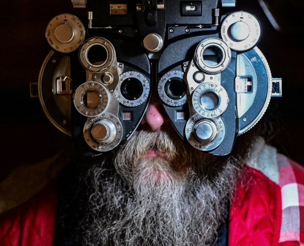 Optomotrist Dr. Ed Zikoski of Montgomery County, gives Sean Griffith of Bethlehem an eye examination Dec. 6, 2025, at the free pop-up clinic offering dental, vision and medical services held at Northeast Middle School in Bethlehem. (Monica Cabrera/The Morning Call)